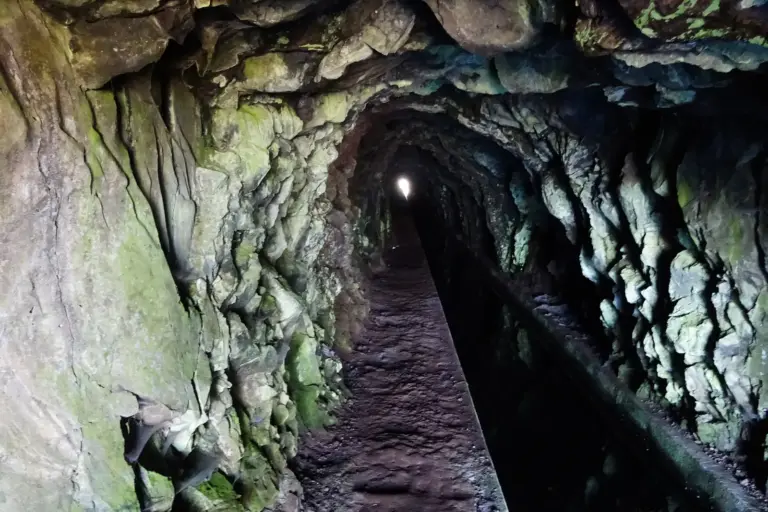 Unbeleuchteter Levada-Tunnel, am Ende nur ein Lichtpunkt