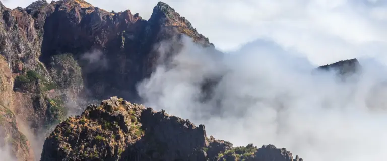 Rock ridge at Pico do Arieiro with cloud pouring around it
